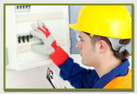 electrical engineer with yellow helmut fixing a circuit board