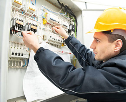 qualified electrician testing a fuse box